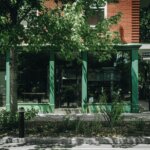 Commerce situé au coin d'une rue et sa vitrine de façade et de la végétation sur le trottoir